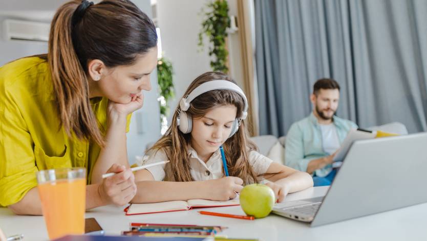 mother helping child with laptop