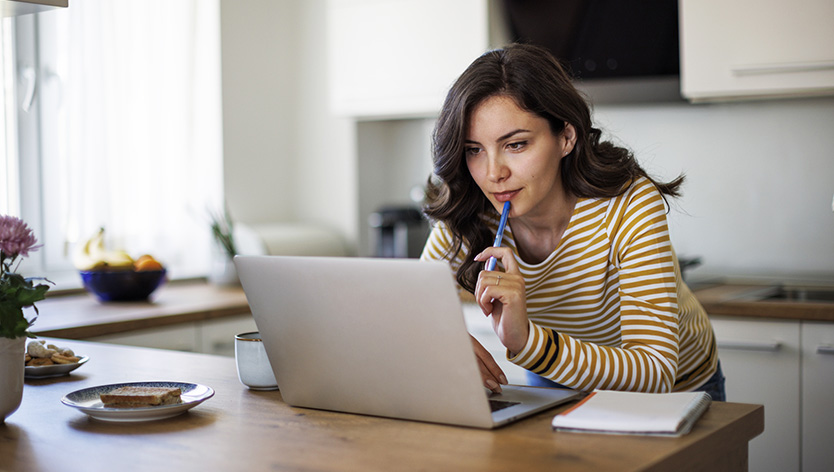 woman thoughtfully looking at laptop