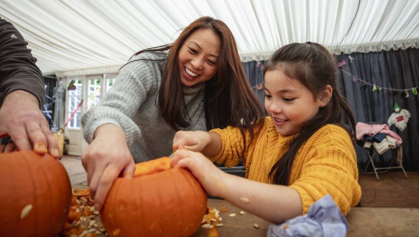 Woman and child carving a pumpkin