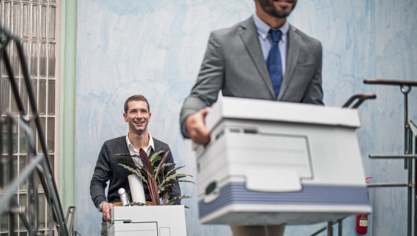 Two gentlemen carrying moving boxes