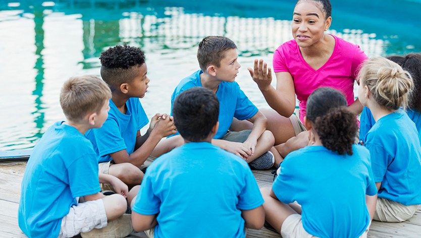 Camp counselor instructing campers