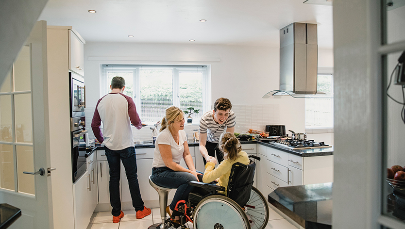 Family interacting with their daughter who is sitting in a wheelchair