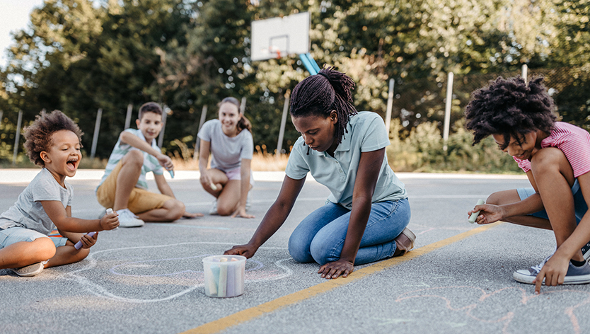 Camp counselor using chalk with campers