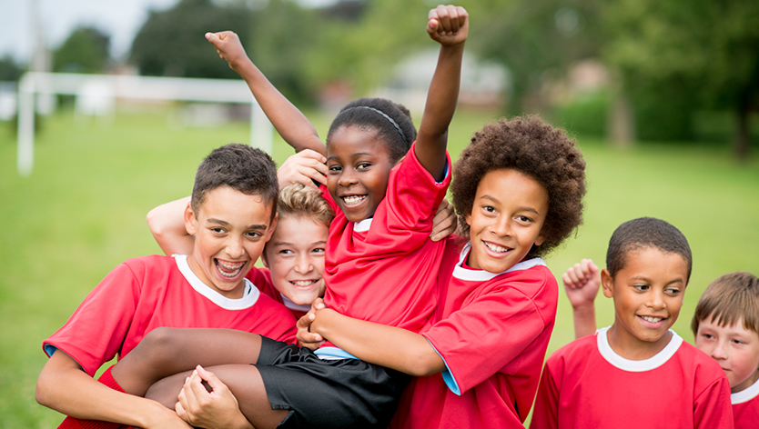 Kids in red soccer jerseys cheering