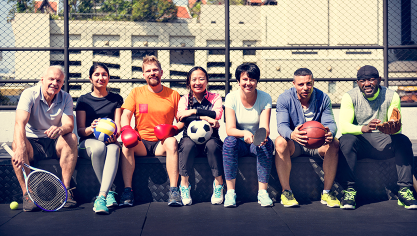 Group of athletes holding different sports equipment