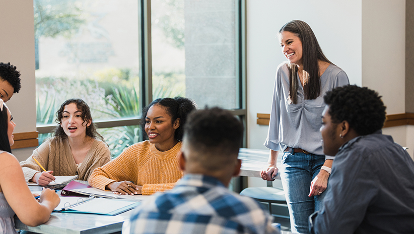 Teacher listening as students brainstorm together