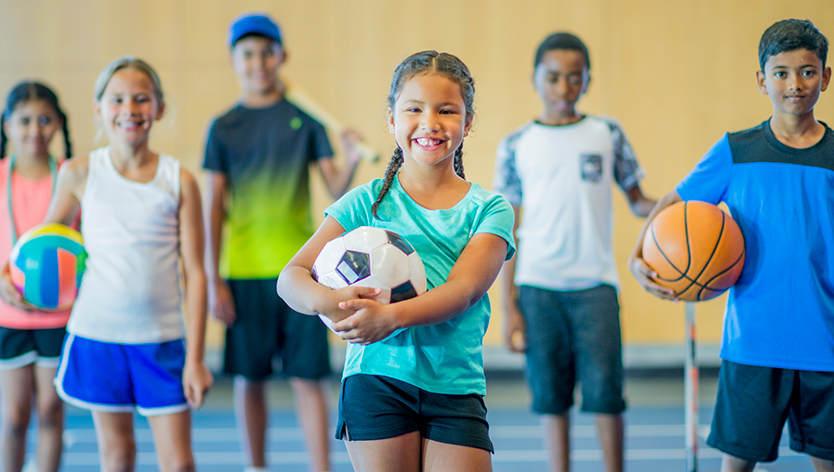 Children holding different sports gear