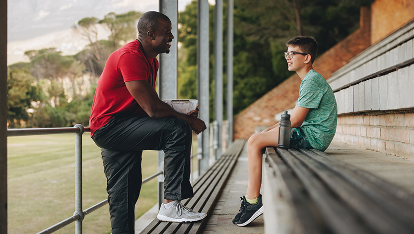 Sports coach talking to his student