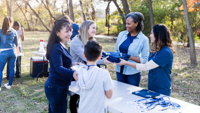 people at a table handing out a shirt