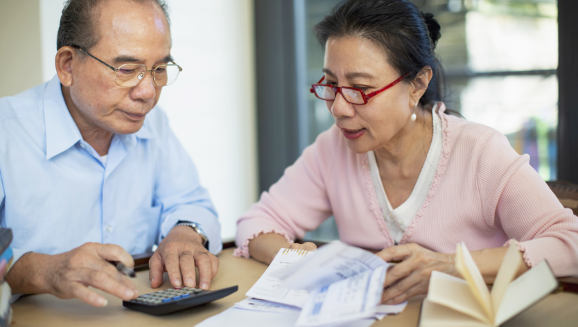 older couple in front of calculator