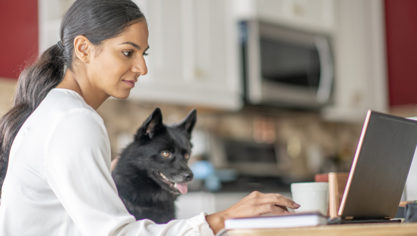 woman on computer with a dog