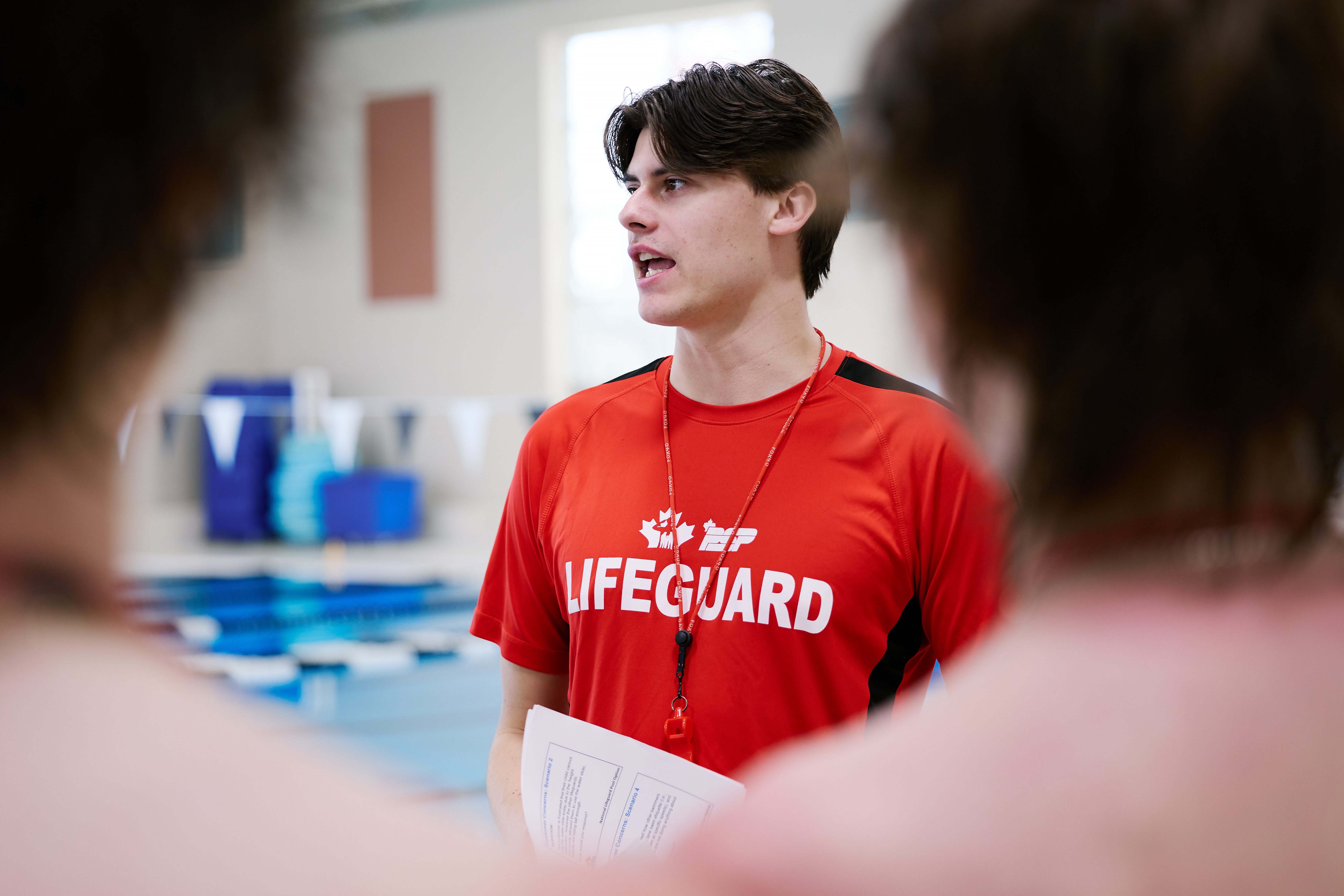 A PSP lifeguard delivering lifeguard training in front of a pool. 