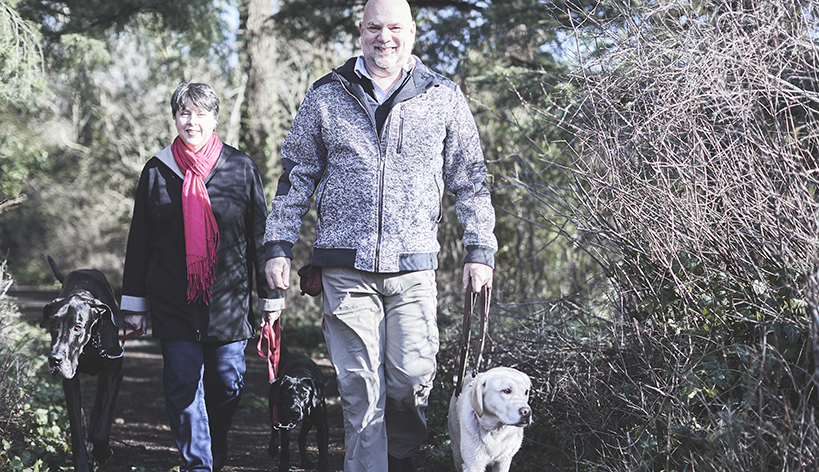 veteran and wife walking dog in woods