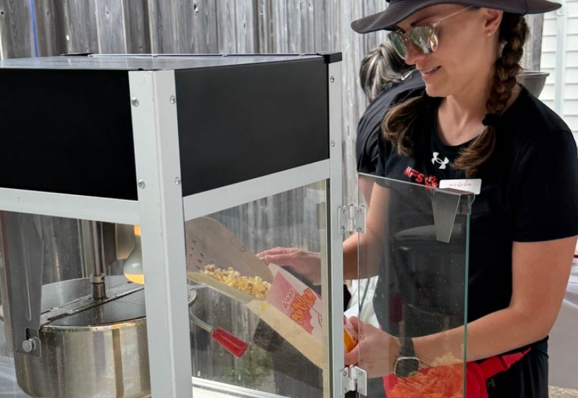 A picture of an MFS Greenwood team member serving popcorn