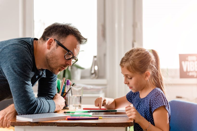 Tutor and child sitting at desk