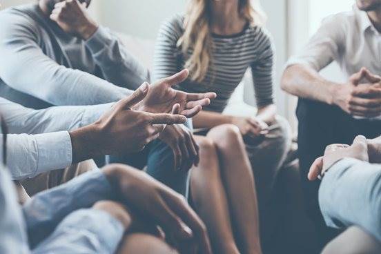 the hands of people sitting closely and speaking together