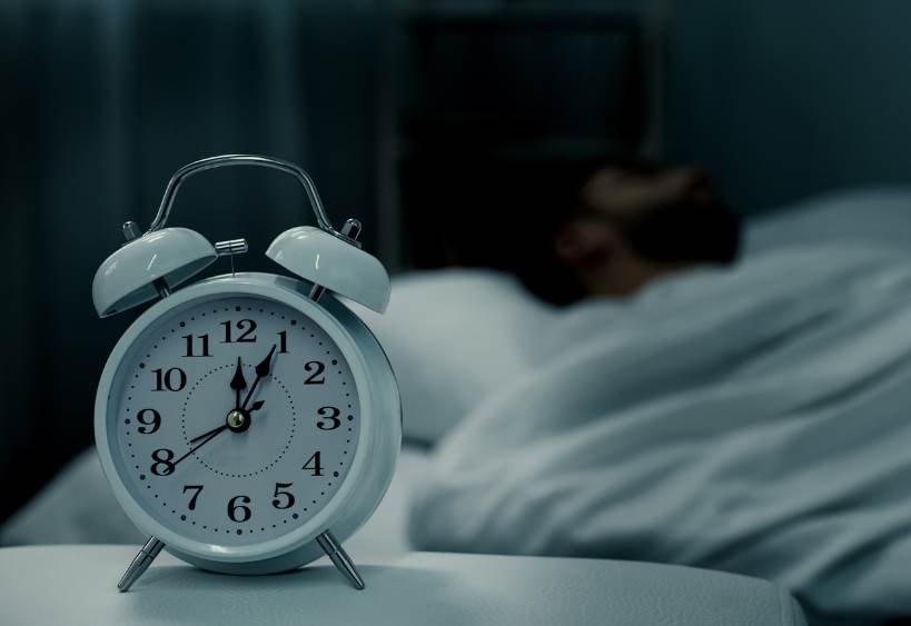 Alarm clock next to someone sleeping