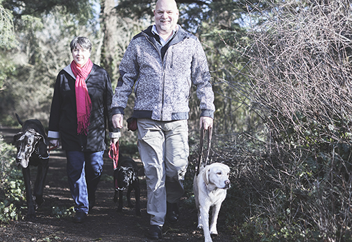 Veteran and wife walking dog in woods