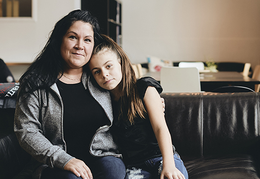 Mother hugging child on couch
