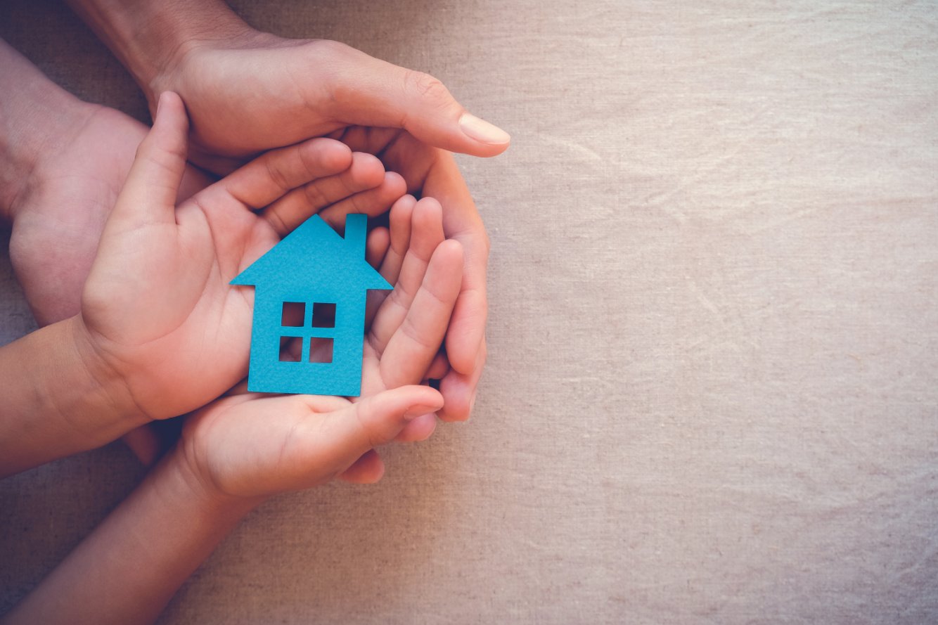 hands holding a blue paper home