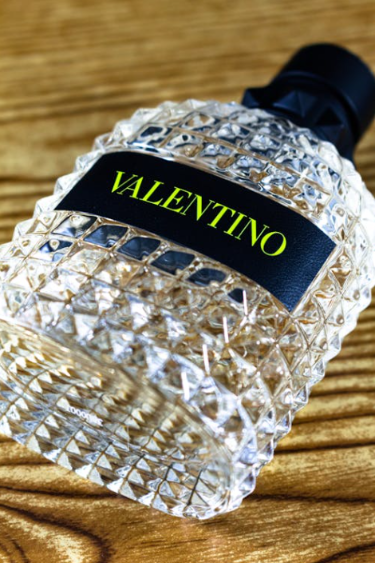 A bottle of Valentino perfume laying on a table